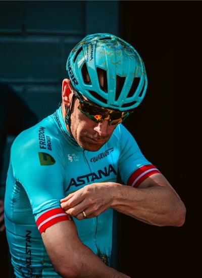 Team Astana rider wearing Limar cycling helmet while adjusting sleeve
